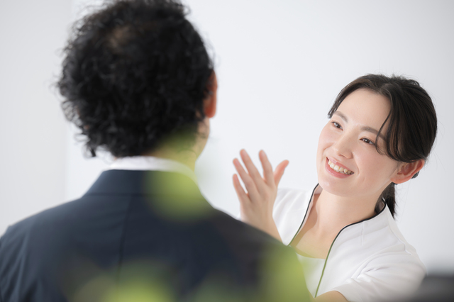 クリニックのスタッフが男性にプランの内容を説明している様子