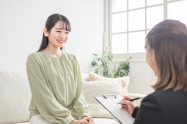 ソファに座った女性がカウンセラーからプランの説明を受けている様子